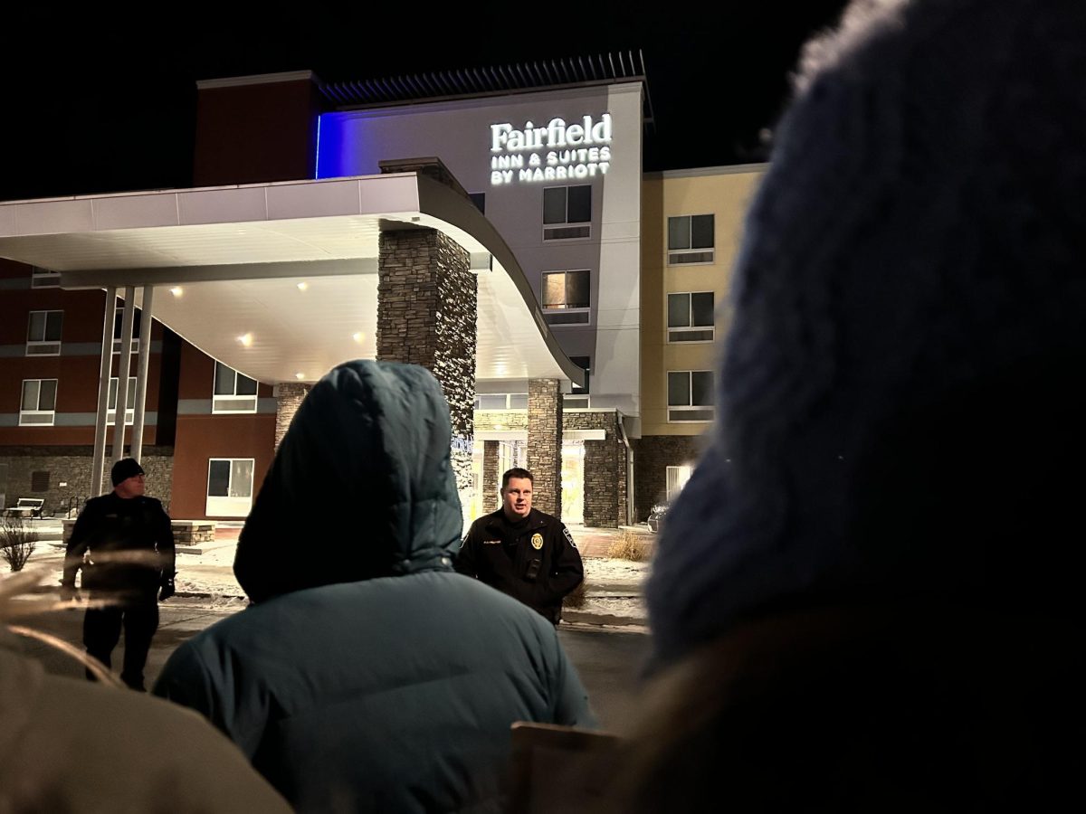 Northfield Police officers speak to noise protesters in front of the Fairfield Inn on Monday night.